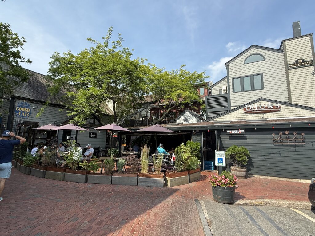 A waterfront view of Diego’s Newport RI on Bowen’s Wharf featuring colorful outdoor seating, vibrant décor, and the busy harbor in the background.