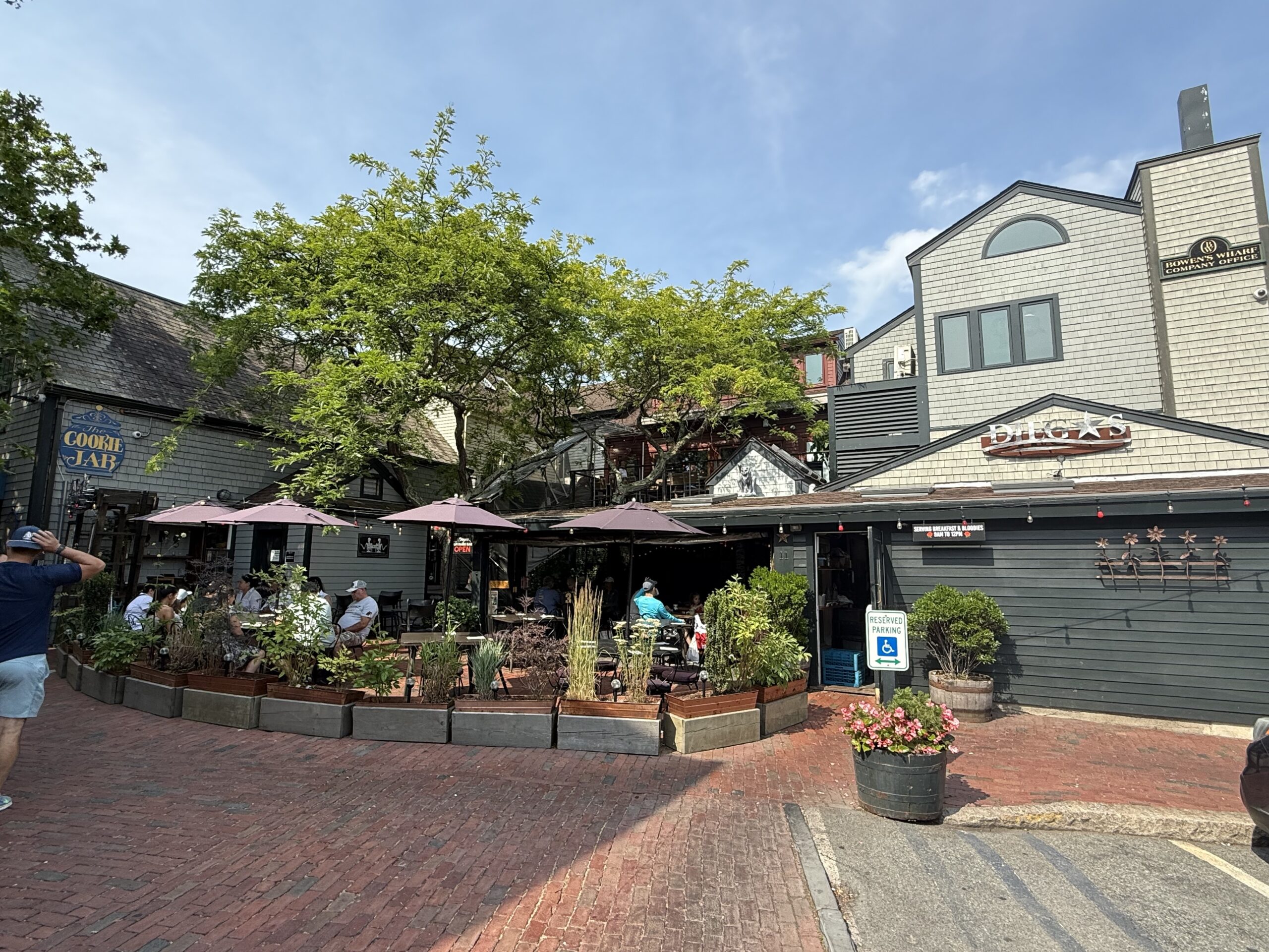 A waterfront view of Diego’s Newport RI on Bowen’s Wharf featuring colorful outdoor seating, vibrant décor, and the busy harbor in the background.