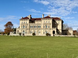 The Breakers mansion in Newport RI viewed from the back lawn with ocean facing architecture and manicured grounds.